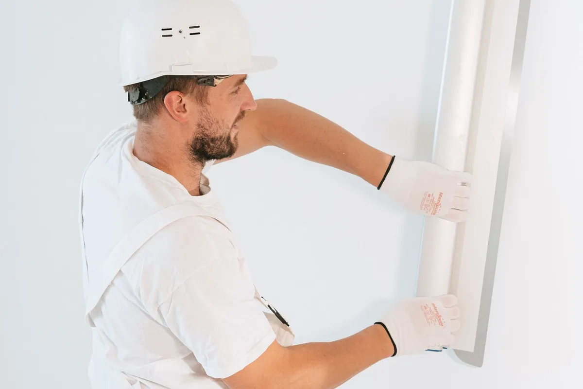 Illustrative photo of a worker handling a drywall panel